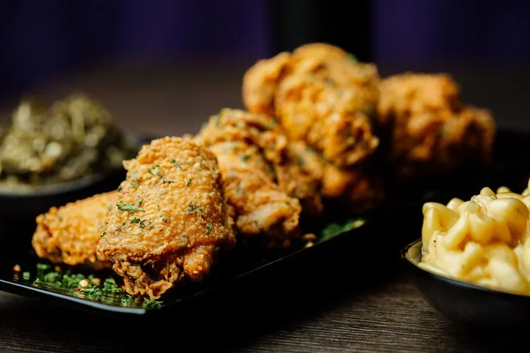 Cajun fried chicken wings with collard greens and mac and cheese